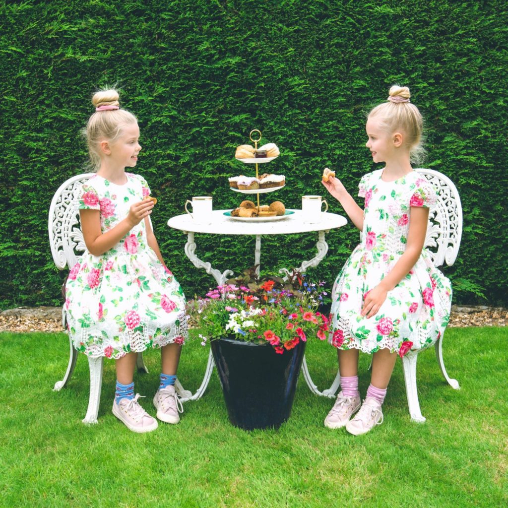 two young girls enjoying afternoon tea in the garden