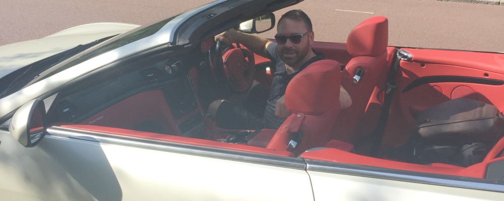 Man in driving seat of Maserati, roof down