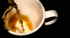 Tea being poured into white teacup