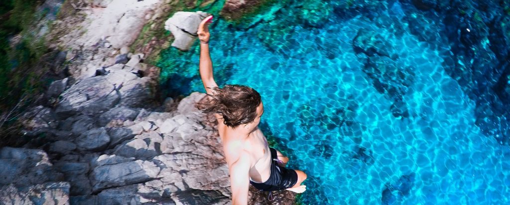 Doing rather than having - man cliff jumping