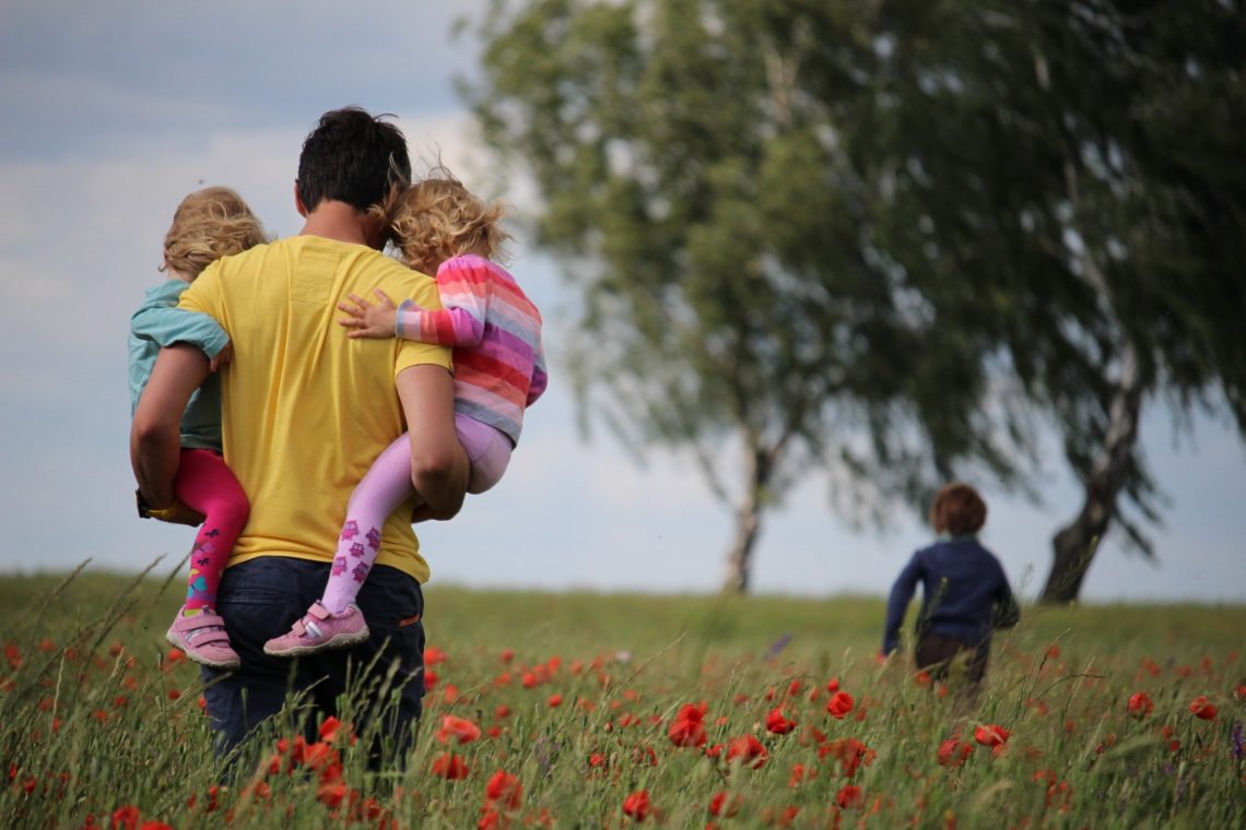 father and his kids in a field