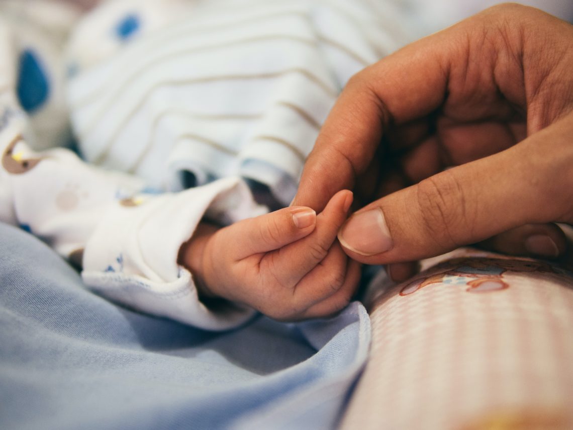 mother holding small babys hand