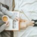 woman reading a book an enjoying a hot drink