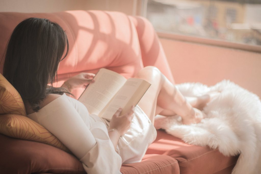 woman reading a book on the sofa